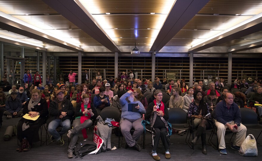 A crowd of people fills the over flow room during the public hearing on Wednesday, November 1, 2017, at City Hall in Seattle.