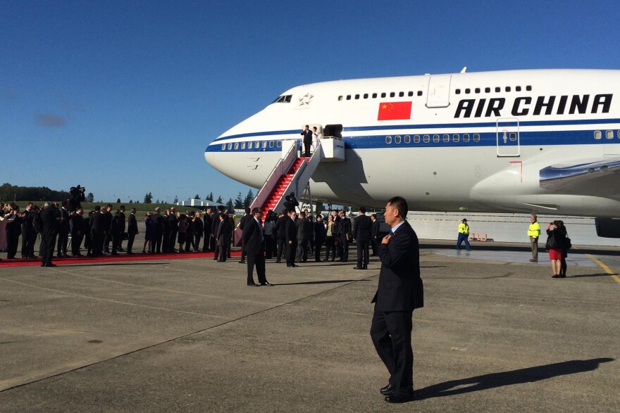 People form a greeting line as Chinese President Xi Jinping and his wife step out of a Boeing 747 at Everett's Paine Field.