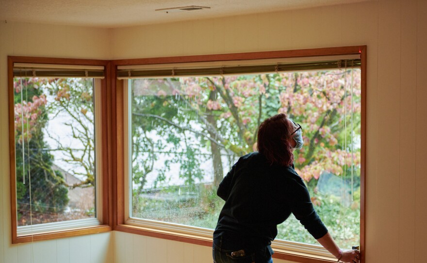 Jackie Zusi-Russell, a home assessor for the Community Energy Project, conducts a home energy audit in Portland. Her work includes measuring the square footage of windows and checking what type of coating (if any) they have.