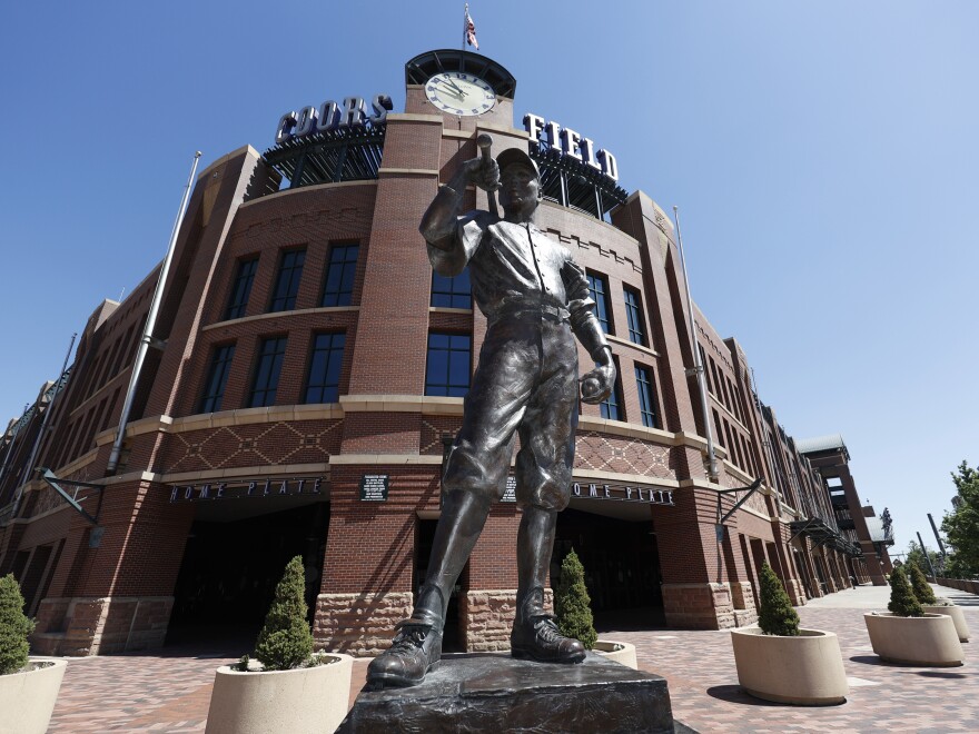 A bronze baseball player stands outside Coors Field in Denver, one of the stadiums idled during the coronavirus outbreak. The league and players association have agreed to  league is waiting for the players' union to respond to whether it will agree to play a shortened season beginning in late July.