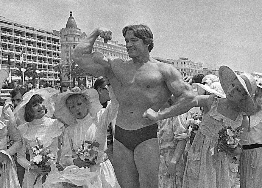 FILE - In this May 20, 1977 file photo, Arnold Schwarzenegger shows off his body for an appreciative beach audience in Cannes, France, ahead of the presentation of his film "Pumping Iron" at the Cannes Film Festival. The Cannes Film Festival officially gets underway on Wednesday, May 11, 2016 and as usual it's set to be one of the most dazzling events in the European entertainment calendar. The festival, in its 69th year, brings a mix of Hollywood A-listers and world cinema auteurs to the French Riviera. (AP Photo, File)