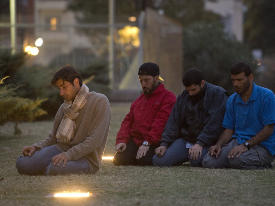 Former Guantanamo prison inmates (from left) Syrian Ahmed Adnan Ahjam, Tunisian Abdul Bin Mohammed Bin Abess Ourgy and Syrians Abdelhadi Omar Faraj and Ali Husein Shaaban pray in front of the U.S. Embassy in Montevideo on Wednesday.