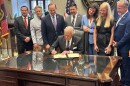 Gov. Henry McMaster signs a law criminalizing the posting of intimate photos without a person's consent on Thursday, May 29, 2025, in the governor’s office in Columbia, S.C.
