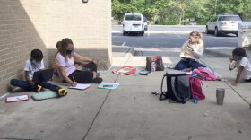 Students work on schoolwork outside the University City Regional Library -- with the help of the library's free Wi-Fi.