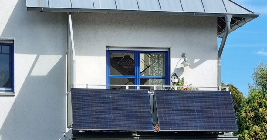 Photo of a balcony with two solar panels affixed to it.