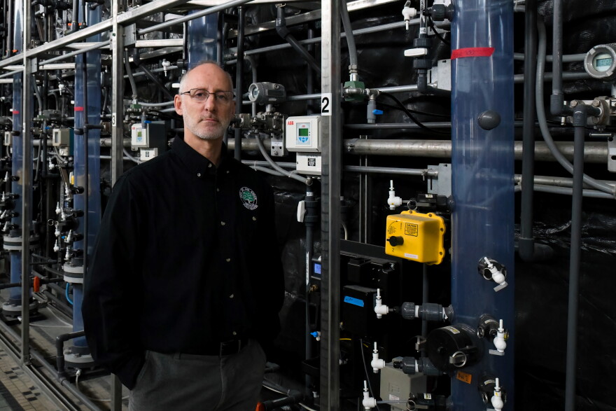  Brian Steglitz is the Ann Arbor Public Services Area Administrator. He and his team are responsible for keeping the city's water safe. The clear pipes behind him are a testing ground for treatments designed to strip contaminants from the city's water.