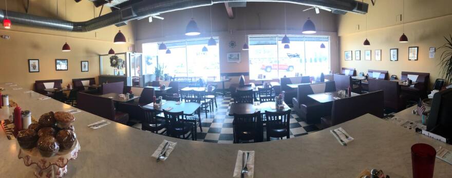 A picture of a restaurant with red booths and a black and white checkered floor 