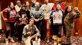 A group of people stand with a 'Truthsgiving' poster. 