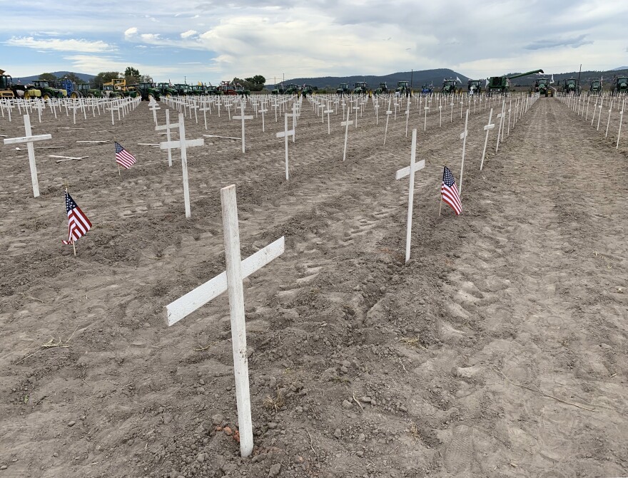 Wooden crosses and a line of tractors at a Klamath Basin rally in 2020 meant to symbolize family farms that have gone out of business.