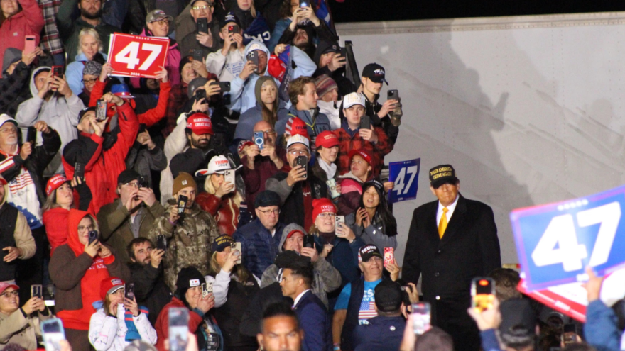 Former President Donald Trump walks on stage at a rally in Traverse City on Friday night. He was three hours late arriving, and some of the crowd had already gone home.