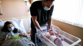 Matthew Carnes prepares to change diapers for his newborn daughter Evelina Carnes as his wife Breanna Llamas keeps watch in the postpartum unit at Providence St. Mary Medical Center.