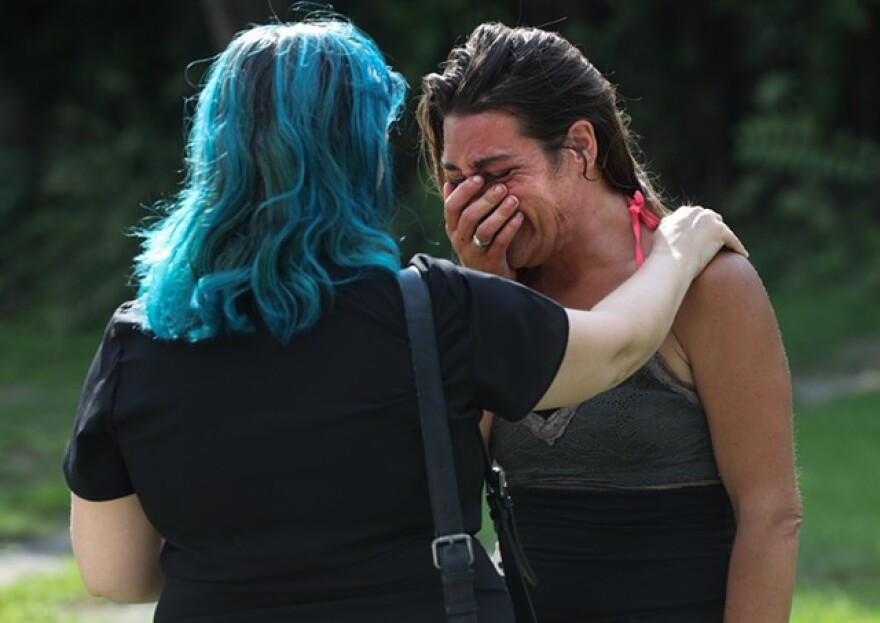 Volunteer Amy D'Amico consoles Erica, a resident of Loomis Street, who is setting out for treatment for heroin addiction.