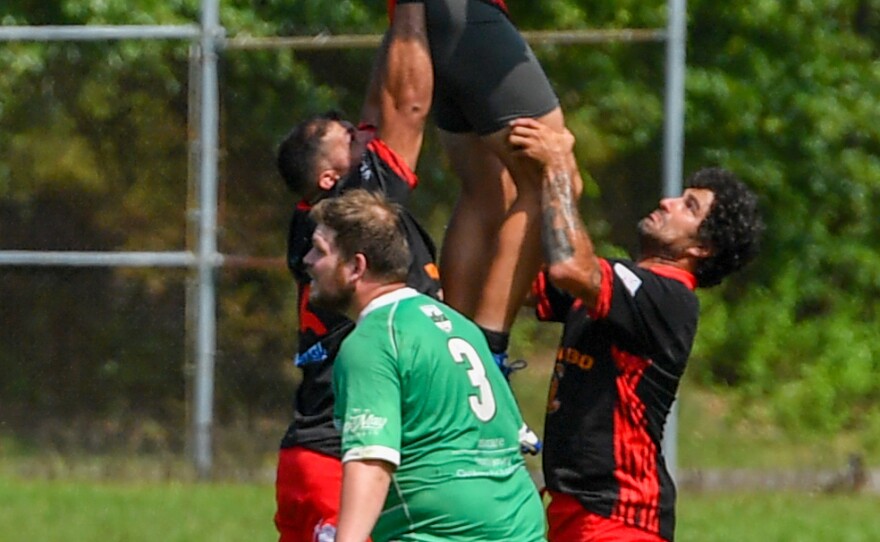 Eric Sovan is raised by teammates to catch the stone.
