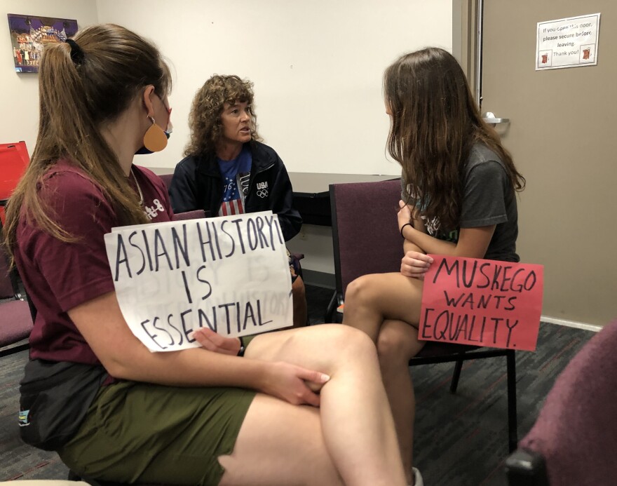 Recently-elected school board member Laurie Kontney (center), who opposed the book "When the Emperor Was Divine" being taught in a Muskego English class, talks to Muskego grad Chloe Adamson (right) after a board meeting Monday.