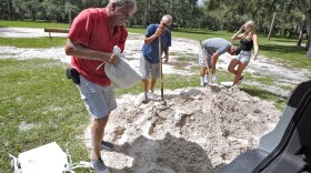 Roger Heim, left, and Terry Smith, second from left, both of Valrico, Fla., fill sand bags in preparation for a weekend storm at the Edward Medard Conservation Park in Plant City, Fla.