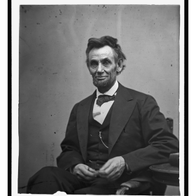  Abraham Lincoln, three-quarter length portrait, seated and holding his spectacles and a pencil