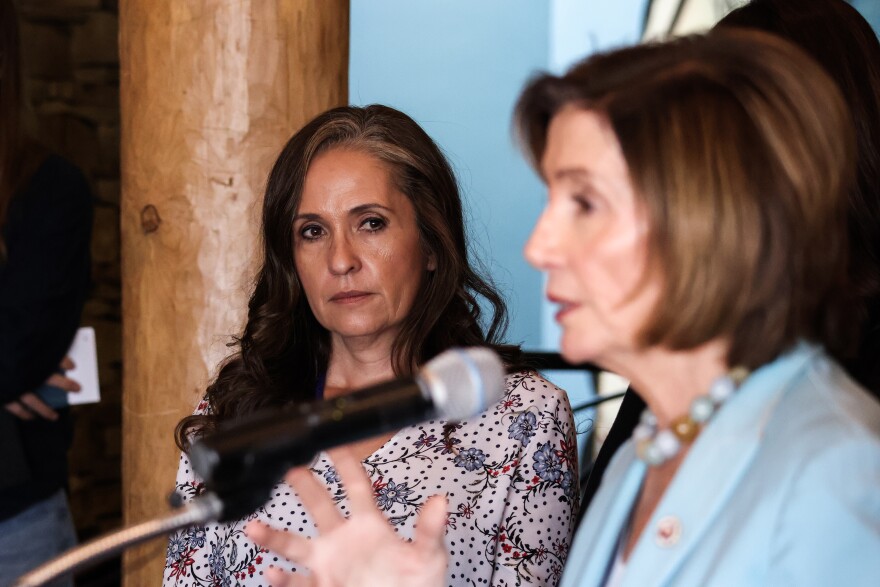 René Gomez, a resident of Rociada, New Mexico watches as Speaker Pelosi addresses the media following the roundtable discussion