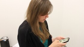 Anchorage massage therapist Ann Dougherty scrolls through rental listings on Craigslist. (Wesley Early/Alaska Public Media)