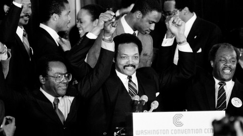 FILE - Jesse Jackson holds his hands up after announcing he will seek the Democratic nomination for president, with his campaign chairman Mayor Richard Hatcher, left, of Gary Ind., and Mayor Marion Barry of Washington, D.C., in Washington, Nov. 3, 1983. (AP Photo/Scott Stewart, File)
