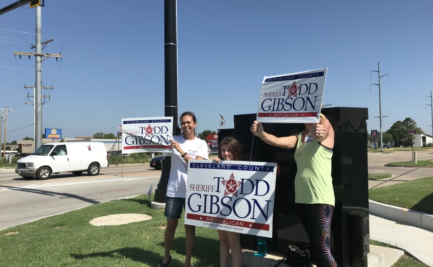 Supporters hold signs for Cleveland County sheriff candidate Todd Gibson. 