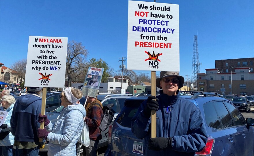 Protesters hold signs at the "No Kings" protest in Bloomington