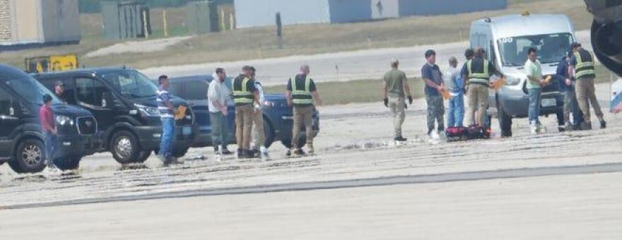 A group of people in shackles is seen at Portsmouth International Airport at Pease prior to an Immigration and Customs Enforcement flight aboard a GlobalX plane.