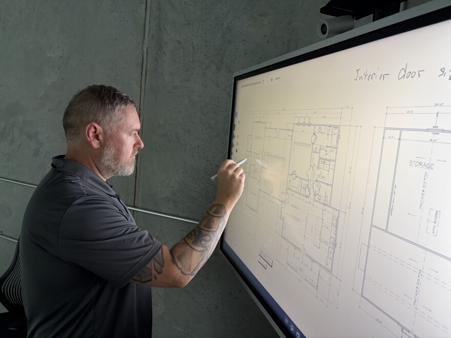 James Milne, co-owner of Walk Your Plans Wichita, makes notes during a client's walk-through. The business opened in June in east Wichita.