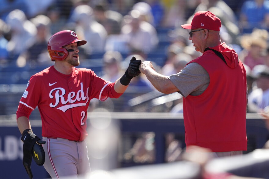 two men, one in a baseball uniform, bump fists