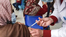 A woman receives a dose of the Pfizer-BioNTech COVID-19 vaccine ahead of the Muslim holy fasting month of Ramadan. (Fethi Belaid/AFP/Getty Images)