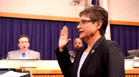 woman raising  her right hand in a court room