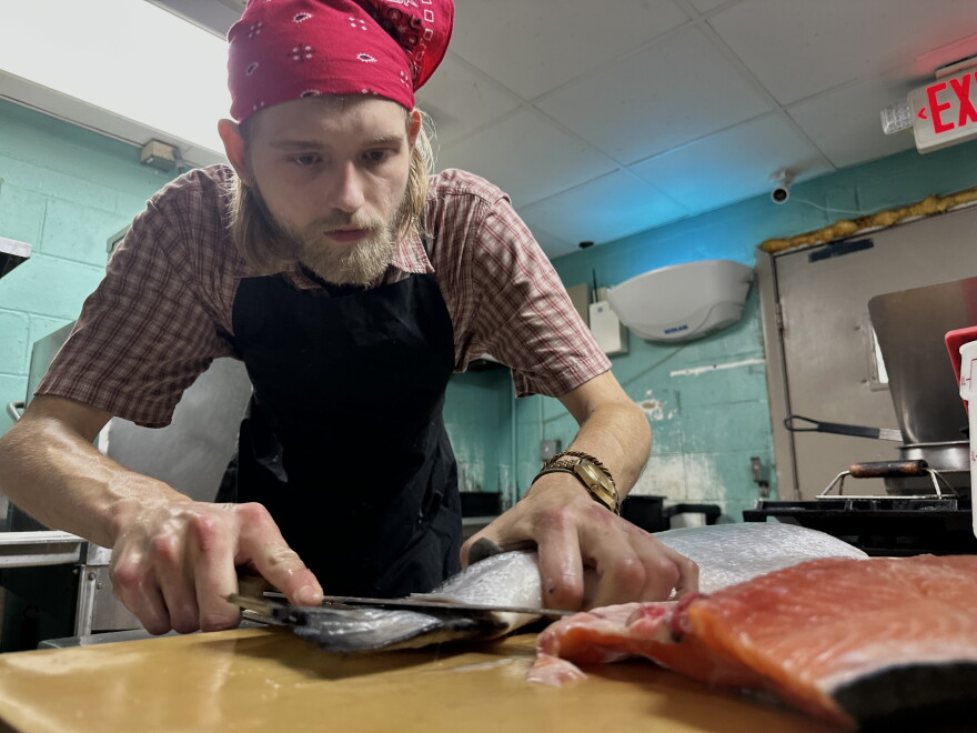 HASS Kitchen head chef Thames Stokes prepares Bakka salmon ahead of Labor Day weekend. The brunch cafe is increasing its food stock by 50% for the weekend. (Jeffrey Serber/WUFT News)