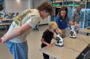 FILE: Staff member Amanda Shuman, second from right, instructs visitors using microscopes in the biomedical and immunology teaching laboratory at the Mote Science Education Aquarium, Monday, Oct. 6, 2025, in Sarasota, Fla.