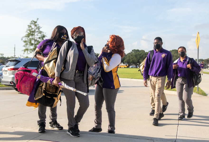  Students adjust their face masks and pose for a first day of school picture outside Edna Karr High School. Aug. 2, 2021.