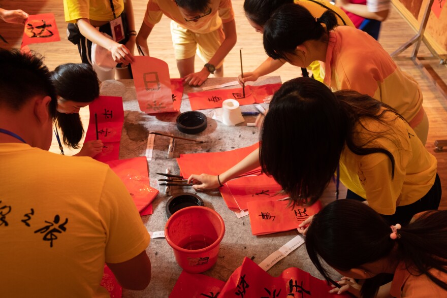 Local students as well as ethnic Chinese students from abroad attend a Chinese calligraphy class.
