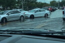 cars try to get through a flooded road