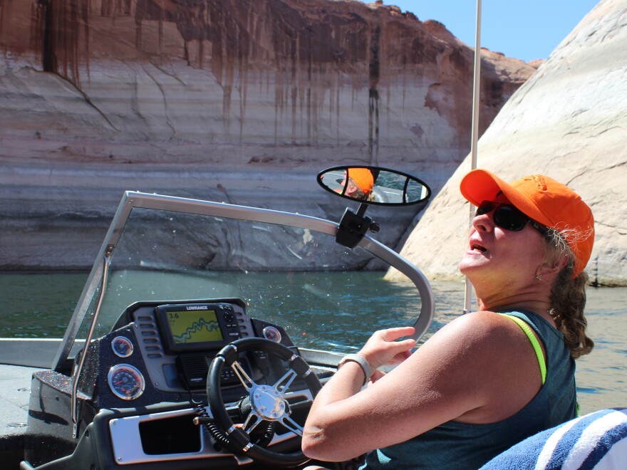 Sheri Facinelli steers a speedboat into a side canyon at Lake Powell. The reservoir is approaching its lowest level since it was created in the 1960s.