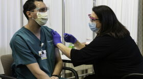 Transportation worker Carlos Rosa of Rochester, left was the first of ten employees at the University of Rochester Medical Center to receive their first dose of the Pfizer-BioNTech COVID-19 vaccine, administered by nurse and director of employee health Laura Caruso, December 14, 2020