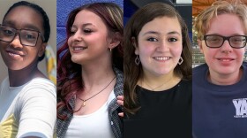 A photo of four teenagers smiling. 