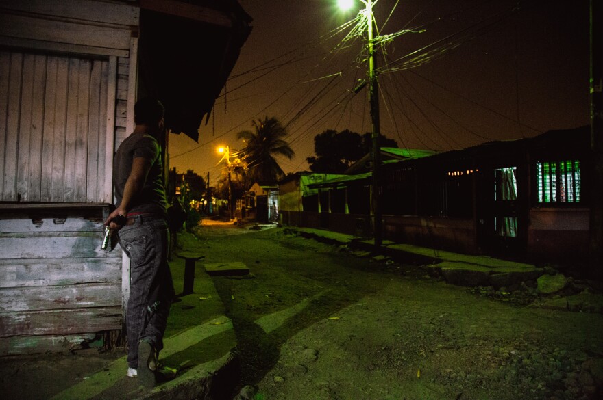 A gang member protects a block of their turf in San Pedro Sula. The decades-long fighting has made enemies of people who might live just a block away from each other, says Ayuso.
