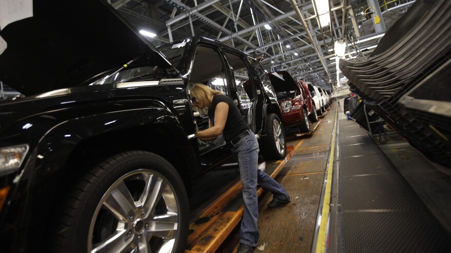 A worker installs carpet into a Jeep Liberty at the Toledo Assembly Complex in Toledo, Ohio, in 2011.