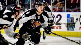 A hockey player wearing a black and white uniform