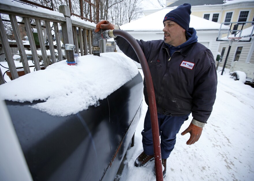 In this photo on Wednesday, Jan. 14, 2014, Paul Dorion, a driver for the Downeast Energy, delivers heating oil to home Portland, Maine.