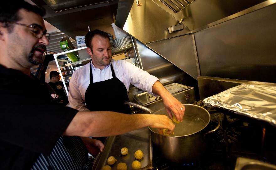 Koslow shows Morning Edition host David Greene how to boil the rolled matzo balls. The chef says he has rolled hundreds of these starchy orbs each day during Passover.