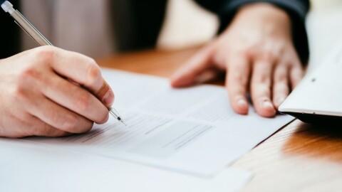 Hand holding pencil filling out a ballot