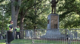 File photo of university police standing watch inside a barricade around the Silent Sam Statue at the University of North Carolina at Chapel Hill as protestors for and against the statue's removal attended rallies near the statue on Tuesday, August 22, 2017.