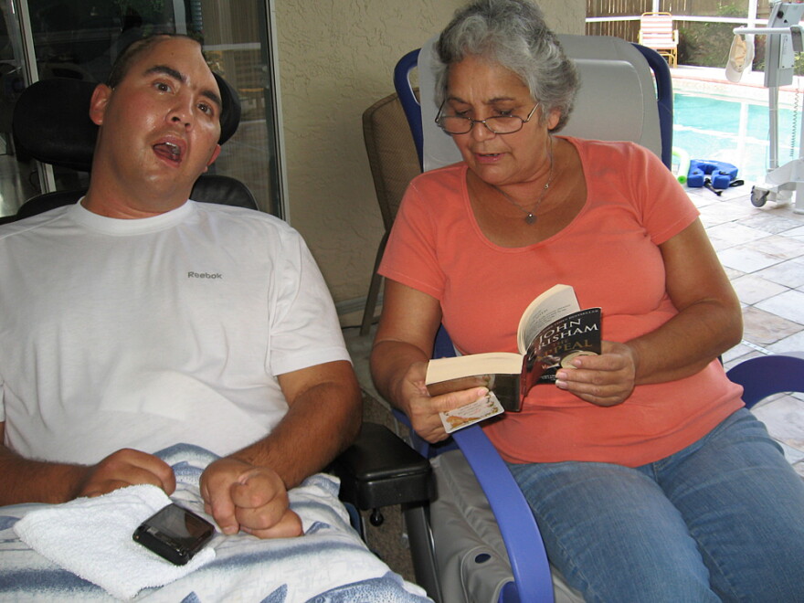 Nellie Bagley (right) reads to Jose at their Tampa home. Doctors say Jose might not perceive or understand the world any more than does a baby.