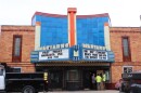 A shot of the outside of the Marianne Theater. A Bellevue Public Works truck sits outside, and two workers talk with the mayor. The city does some mild renovations to keep the building from completely deteriorating. 