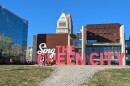 People pose before a 3-D sign reading "Sing the Queen City."