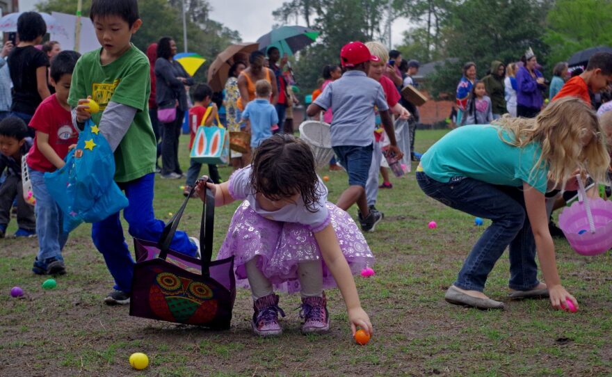 Children reach down to pick up the colorful eggs containing candy at "Eggolution." Hundreds of eggs were strewn across the field, and children were divided into different age groups.