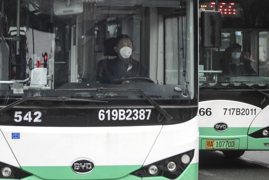 A bus driver wears a mask on Jan. 22 in Wuhan, China. Public transportation is being suspended as of Thursday morning because of concerns about the spreading coronavirus.